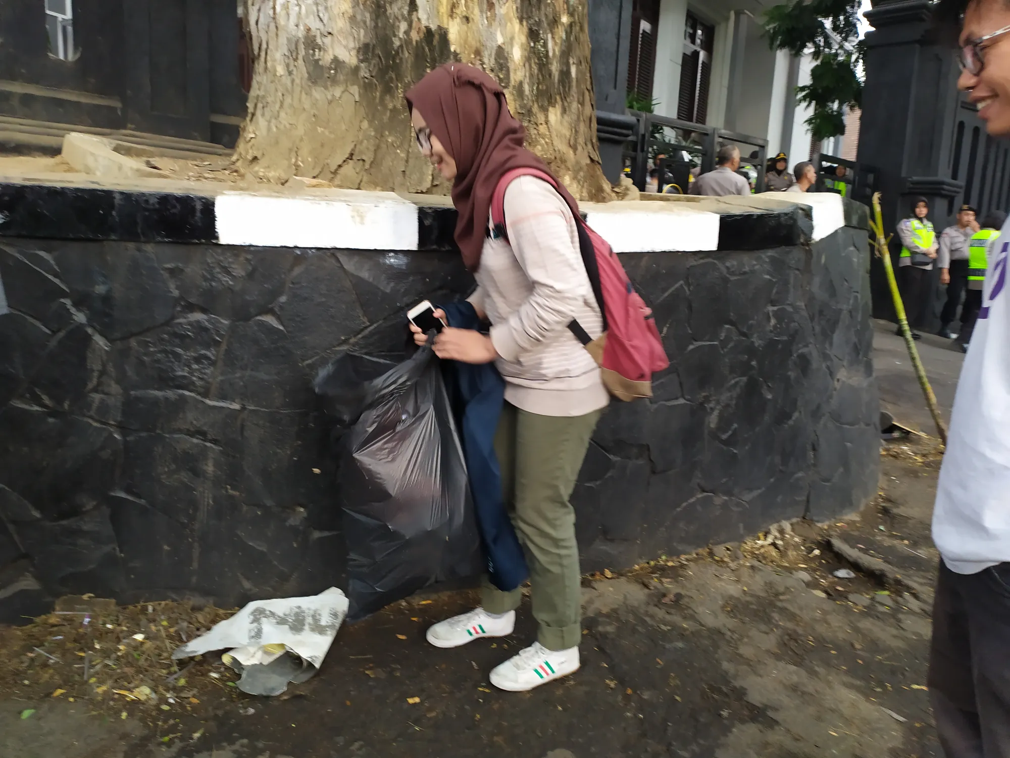 Dua mahasiswa bersih-bersih lokasi pasca aksi demonstrasi. (credit: Kapanlagi.com/Darmadi Sasongko)