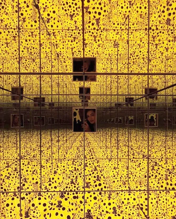 Atiqah di dalam di salah satu ruangan karya Yayoi Kusama. © Instagram.com/atiqahhasiholan
