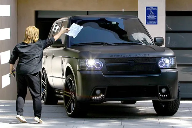 Justin saat mencoba keluar dari rumahnya dan didampingin bodyguard di dalam mobilnya @ dailymail.co.uk