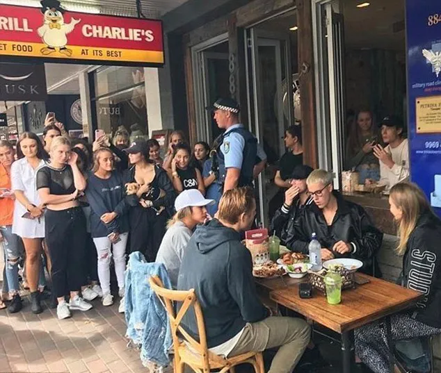 Justin makan sambil dikerumuni oleh para gadis © twitter.com