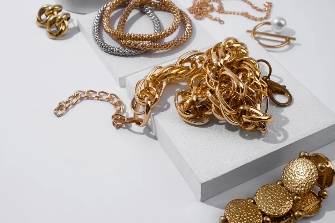 gelang dan kalung rantai emas di atas tatakan. (c) Freepik/freepik