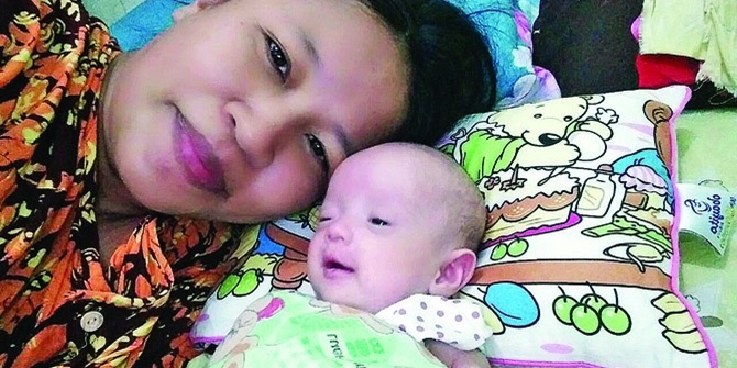 Sang ibu bersama Debora, bayi kecilnya semasa hidup (© Jawa Pos)