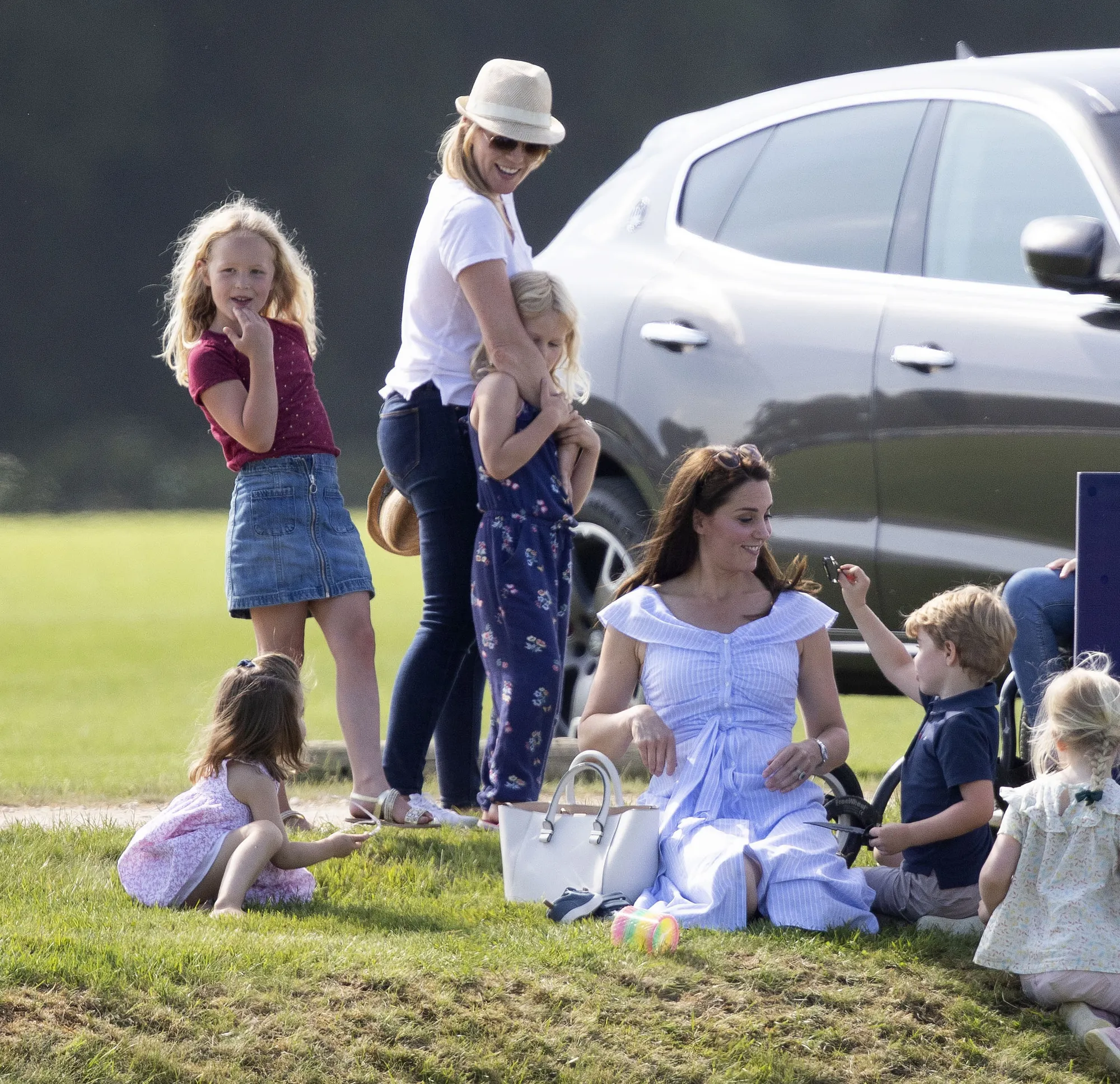 Kate main bareng George dan Charlotte di atas rumput © AP Images