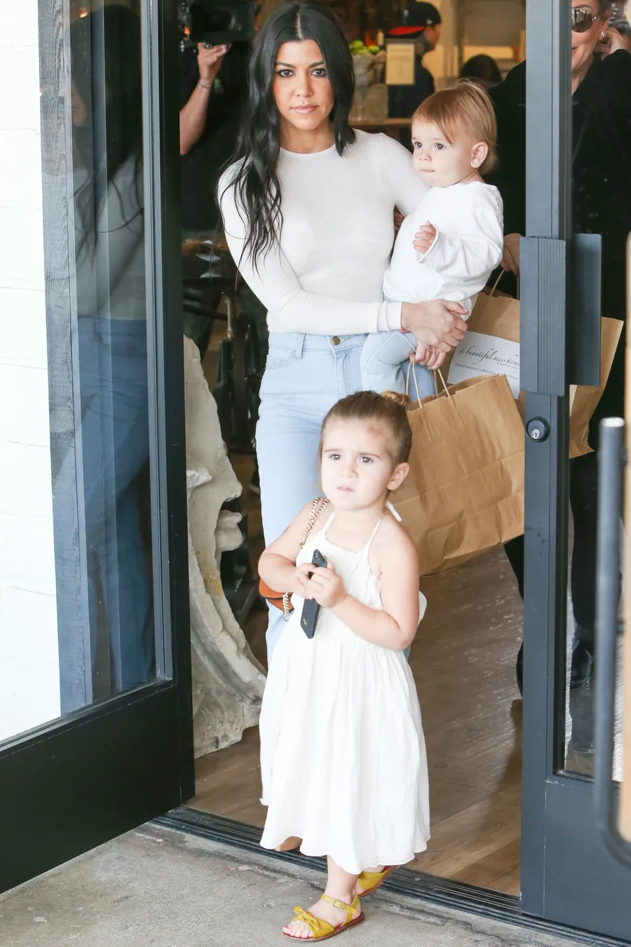 Kourtney dengan dua anaknya. Apakah benar dia hamil? © Fameflynet