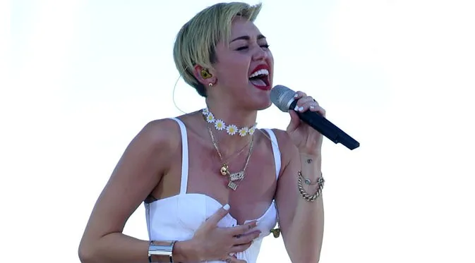 Miley Cyrus memegangi busananya yang melorot. ©hollywoodlife.com