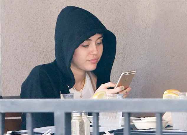 Miley malah asyik dengan ponselnya @ dailymail.co.uk