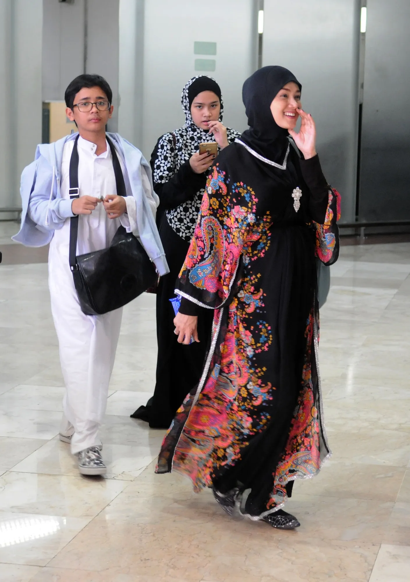 Mulan bersama dua anaknya di Bandara Soekarno Hatta ketika pulang umrah. ©KapanLagi.com/Bayu Herdianto