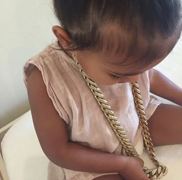 North West tampil sosialita dengan menggunakan kalung emas sangat besar © Instagram/Kim Kardashian