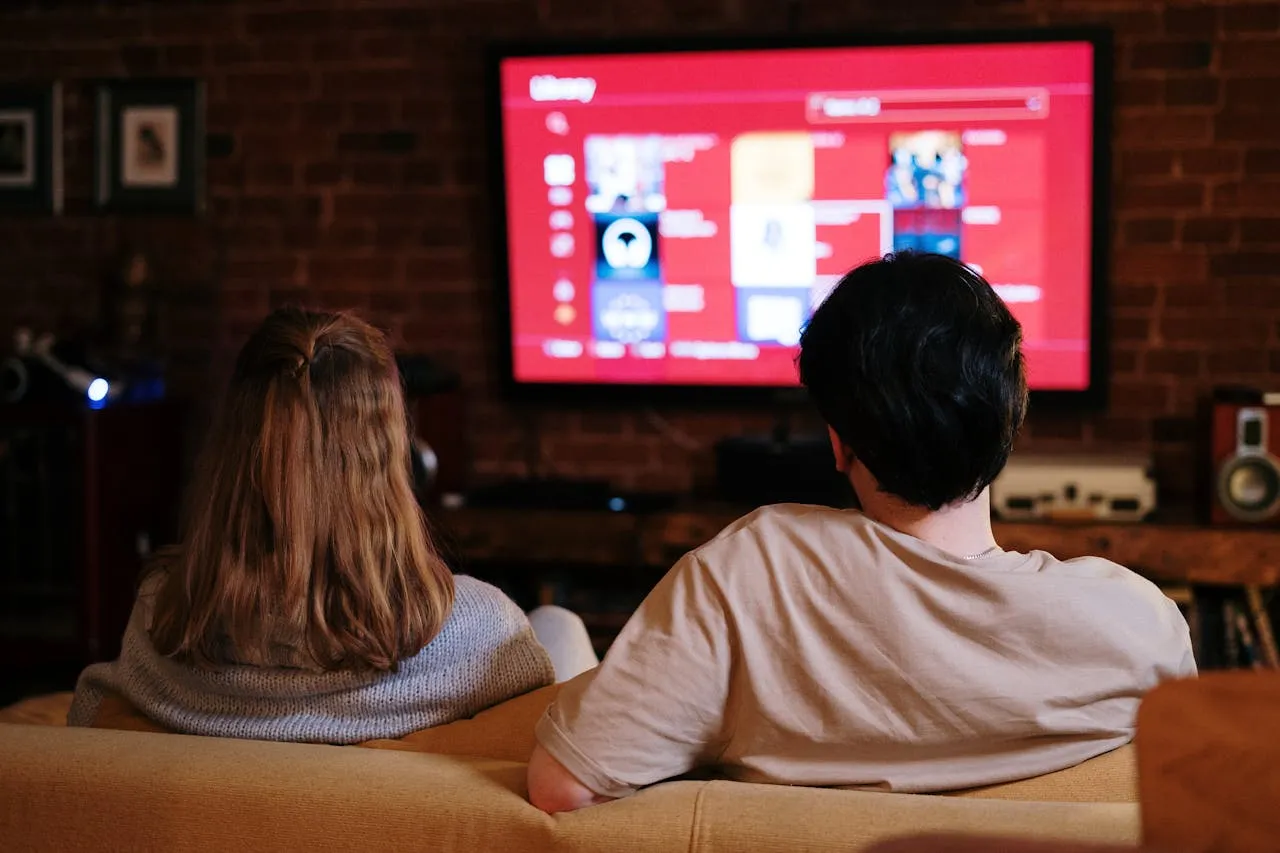 Sepasang kekaasih sedang straming film di smart tv (credit: pexels)
