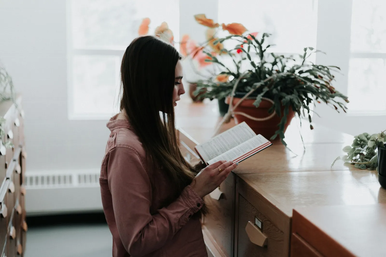 Seorang perempuan sedang membaca buku (credit: unsplash)
