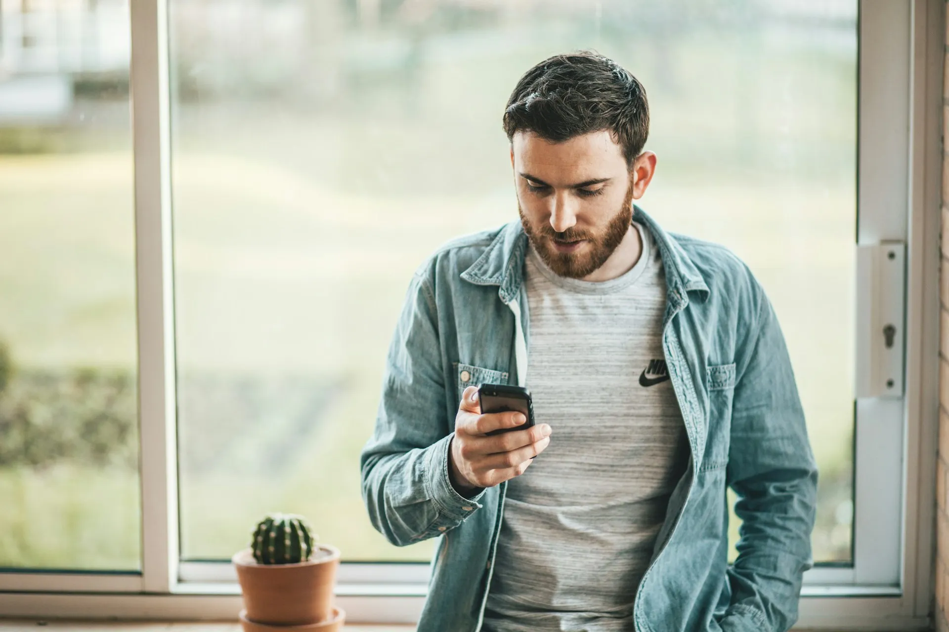 Seorang pria bermain ponsel (credit: Unsplash)