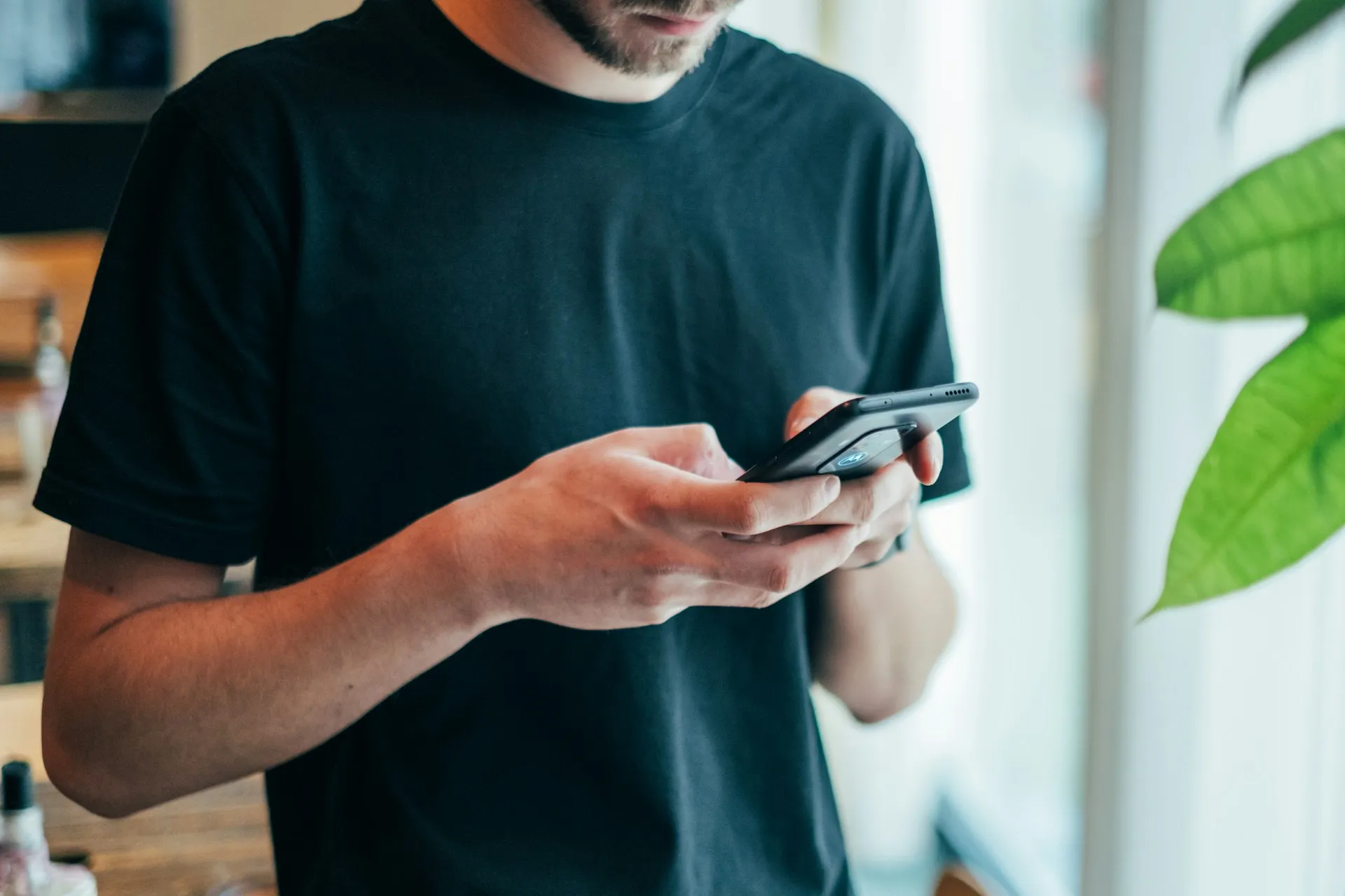 Seorang pria dengan ponselnya (credit: Unsplash)