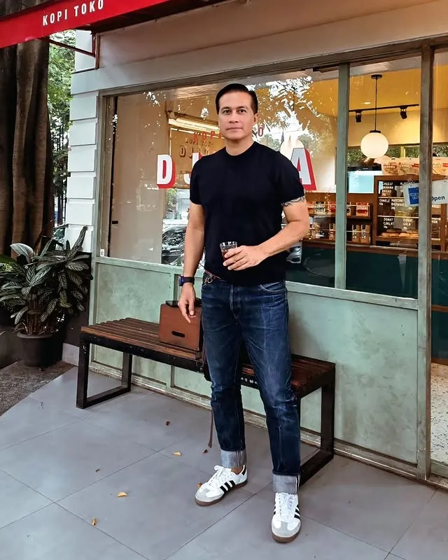 Adjie Pangestu berdiri pegang gelas kopi © instagram.com/adjiepangestu