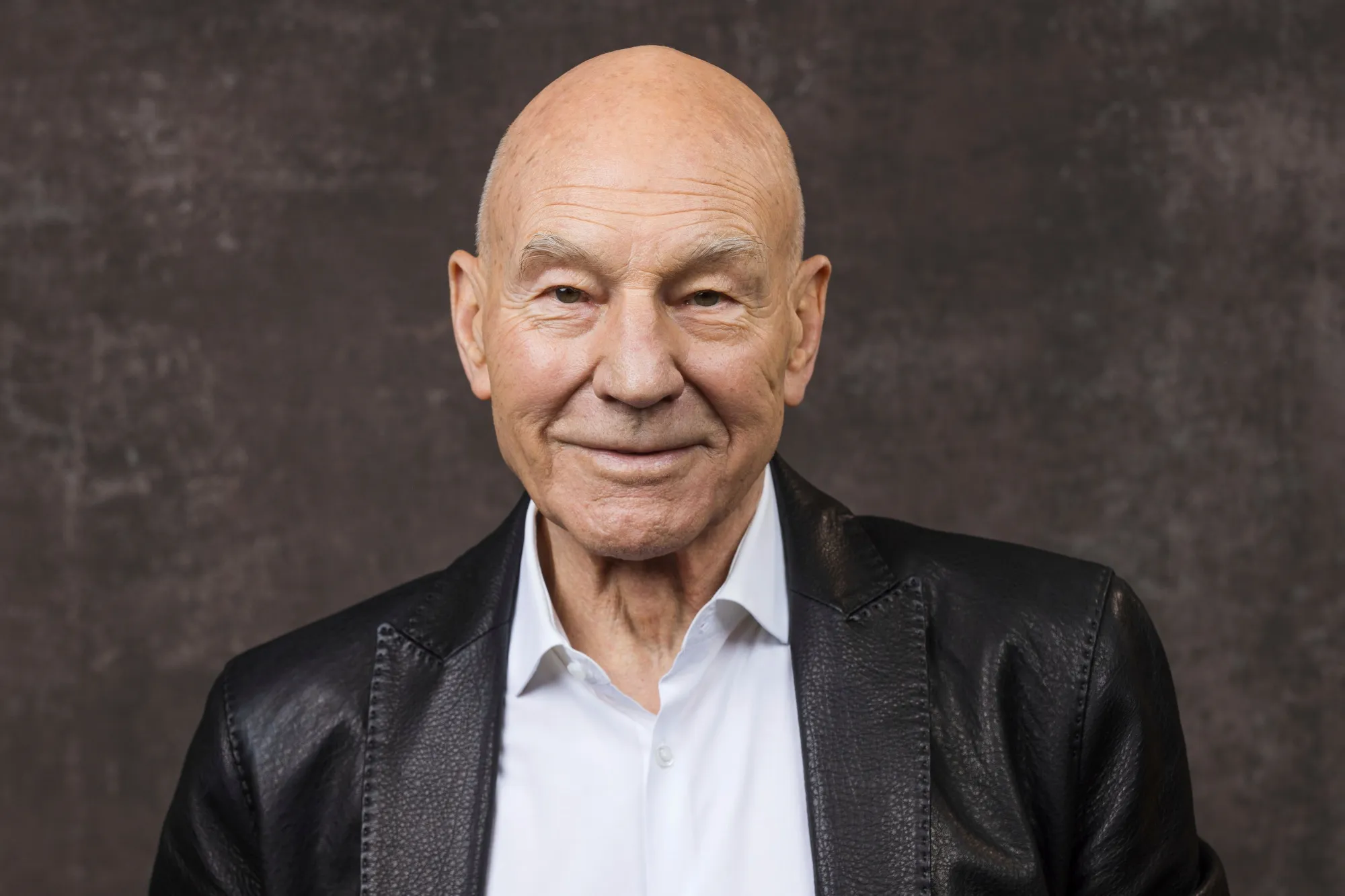 Patrick Stewart pakai jas hitam © Associated Press