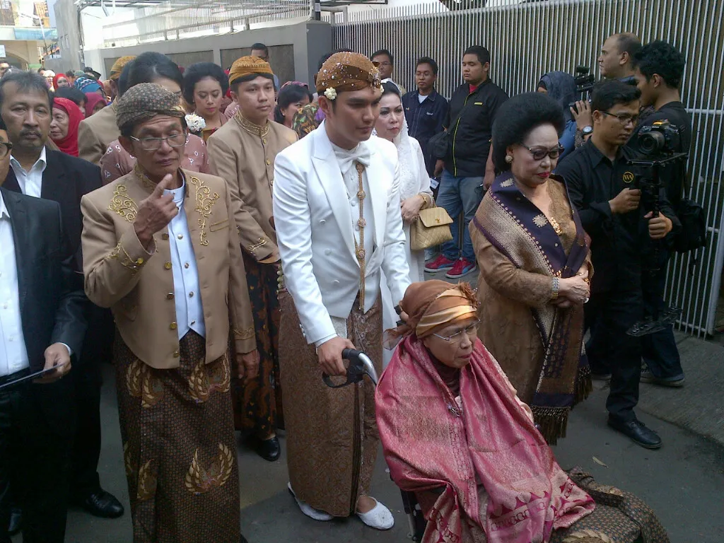 Aldi mendorong kursi roda yang dinaiki ibunya. @KapanLagi.com®/Ruswanto