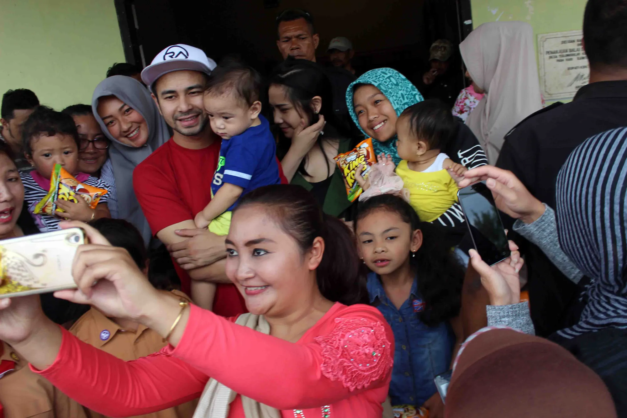 Sejumlah warga setempat yang berebut untuk berfoto bersama Raffi, Nagita, dan anaknya © KapanLagi.com/Darmadi Sasongko