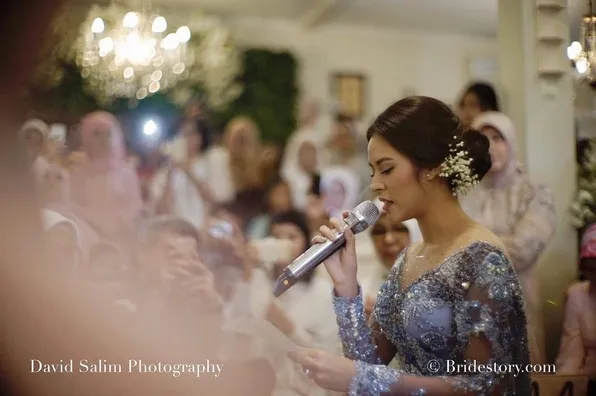 Pada acara yang sama, Raisa sempat ganti busana dengan memakai kebaya warna ungu © IG @thebridestory - @davidsalimphotography