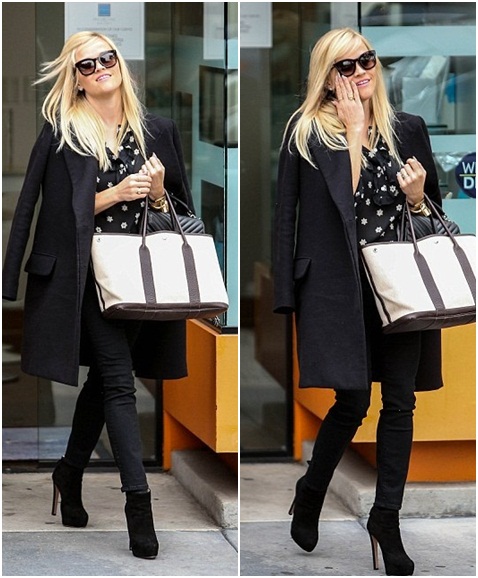 Reese melengkapi outlooknya dengan membawa sebuah tote bag dominasi warna krem dan juga sebuah baguette handbag berwarna hitam © dailymailcouk