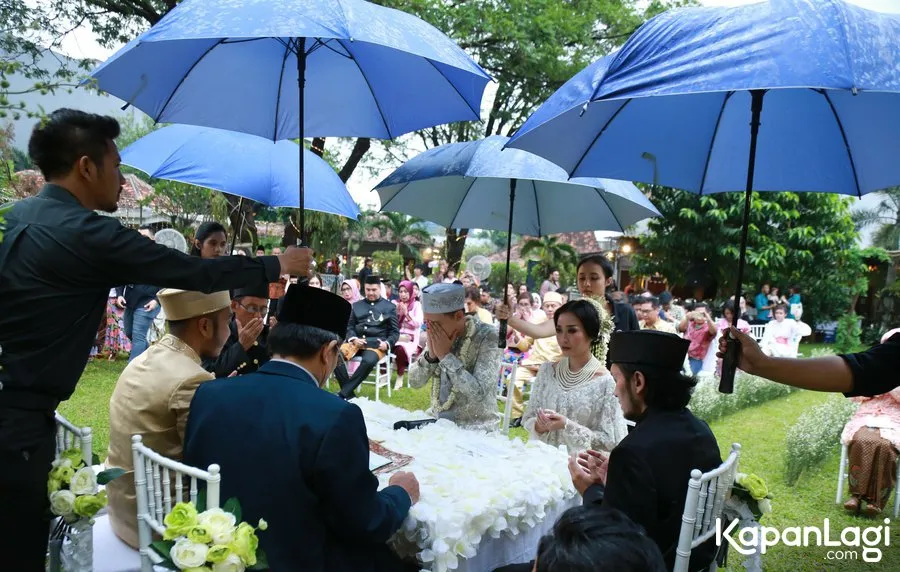 Rinni dan Jevin menikah di bawah hujan. ©KapanLagi.com/Agus Apriyanto