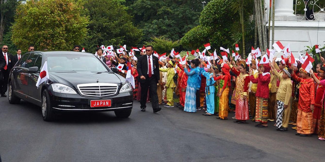 Hampir sama seperti Raja Salman, Perdana Menteri Jepang Shinzo Abe juga disambut oleh parade anak sekolah yang melambaikan bendera dua negara di Istana Bogor © merdeka.com