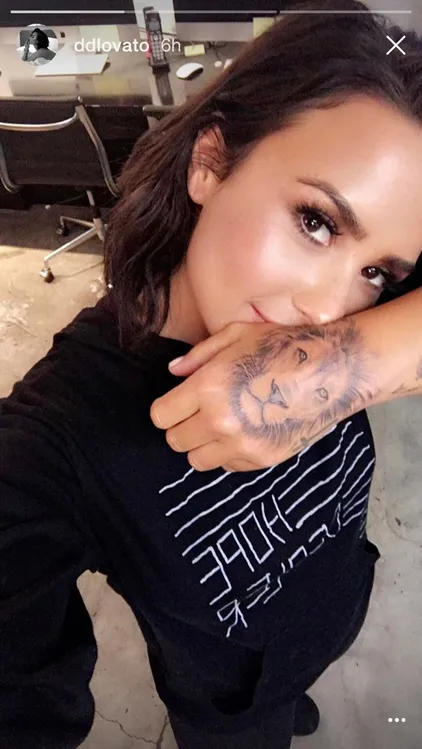 Demi Lovato buat tattoo baru bergambar wajah singa di tangan kirinya © eonline.com/instagram.com/ddlovato