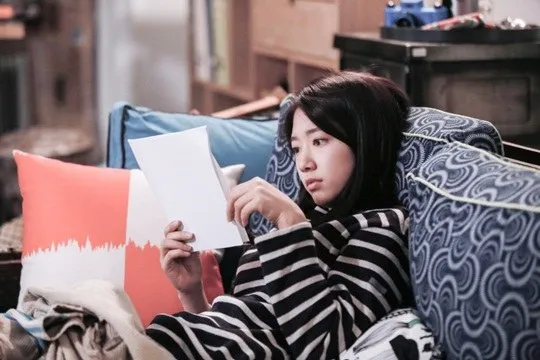 Park Shin Hye pelajari naskah sambil duduk santai di sofa ©soompi.com