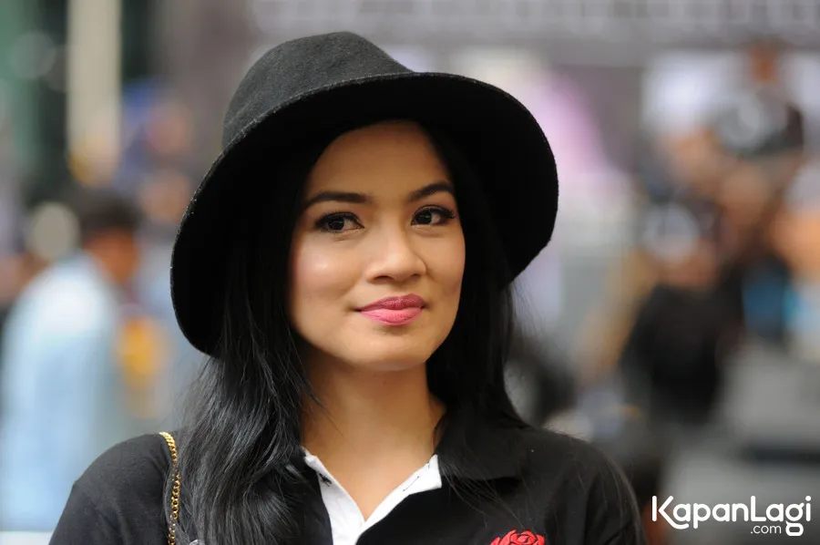 Titi Kamal main gadget saat terjebak macet © KapanLagi.com®/Bayu Herdianto