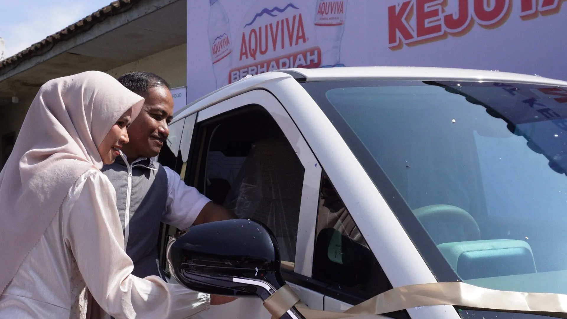 Penyerahan hadiah program Kejutan Tutup Botol AQUVIVA berupa mobil listrik Wuling Air EV ke rumah pemenang. (Foto:Dok.AQUVIVA)