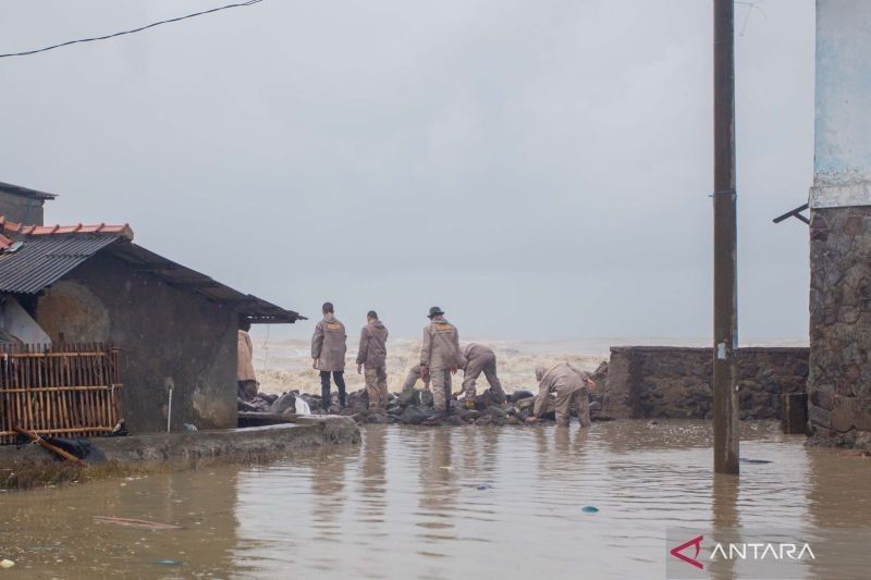 Polisi Bantu Tutup Tanggul Jebol Akibat Banjir Rob di Indramayu