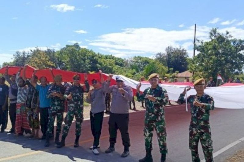 Unik! Warga Perbatasan RI-Timor Leste Arak Bendera Merah Putih Raksasa Ukuran 17x8 Meter Sambut HUT ke-80 RI