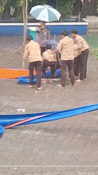 Di Tengah Rintik Hujan, Satpam ini Payungi Guru yang Sedang Salat, Aksinya Mulia Banget