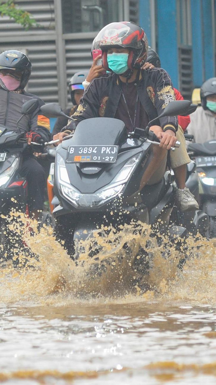 FOTO: Luapan Air Kali Baru di Depan Pasar Induk Kramat Jati Banjiri Jalan Raya Bogor, Lalu Lintas Macet Parah