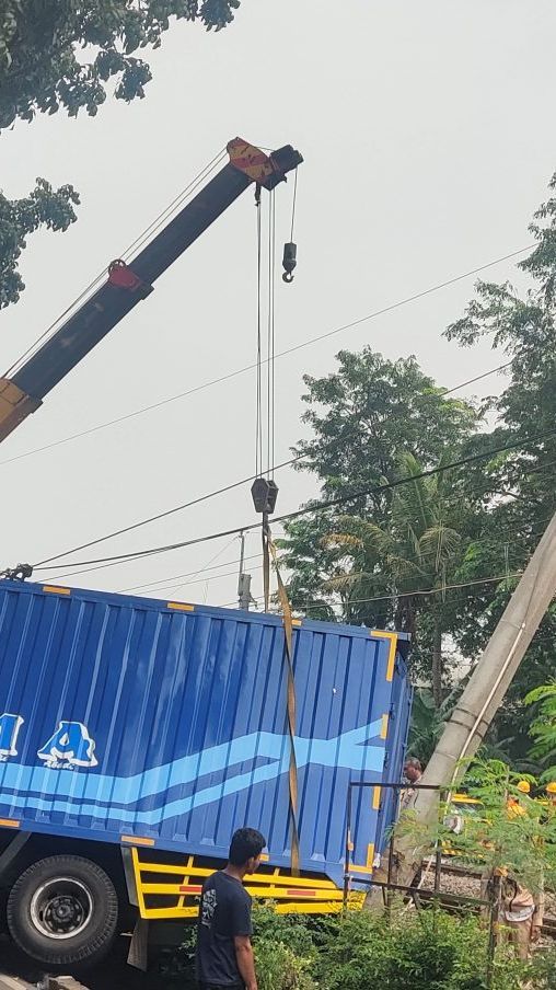 FOTO: Alat Berat Crane Evakuasi Truk Fuso yang Tabrak Tiang LAA KRL Commuter Line hingga Nyaris Roboh