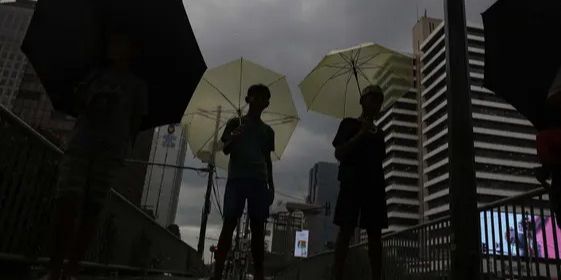 FOTO: Potret Anak-Anak Pengojek Payung di Antara Gedung Bertingkat Jakarta