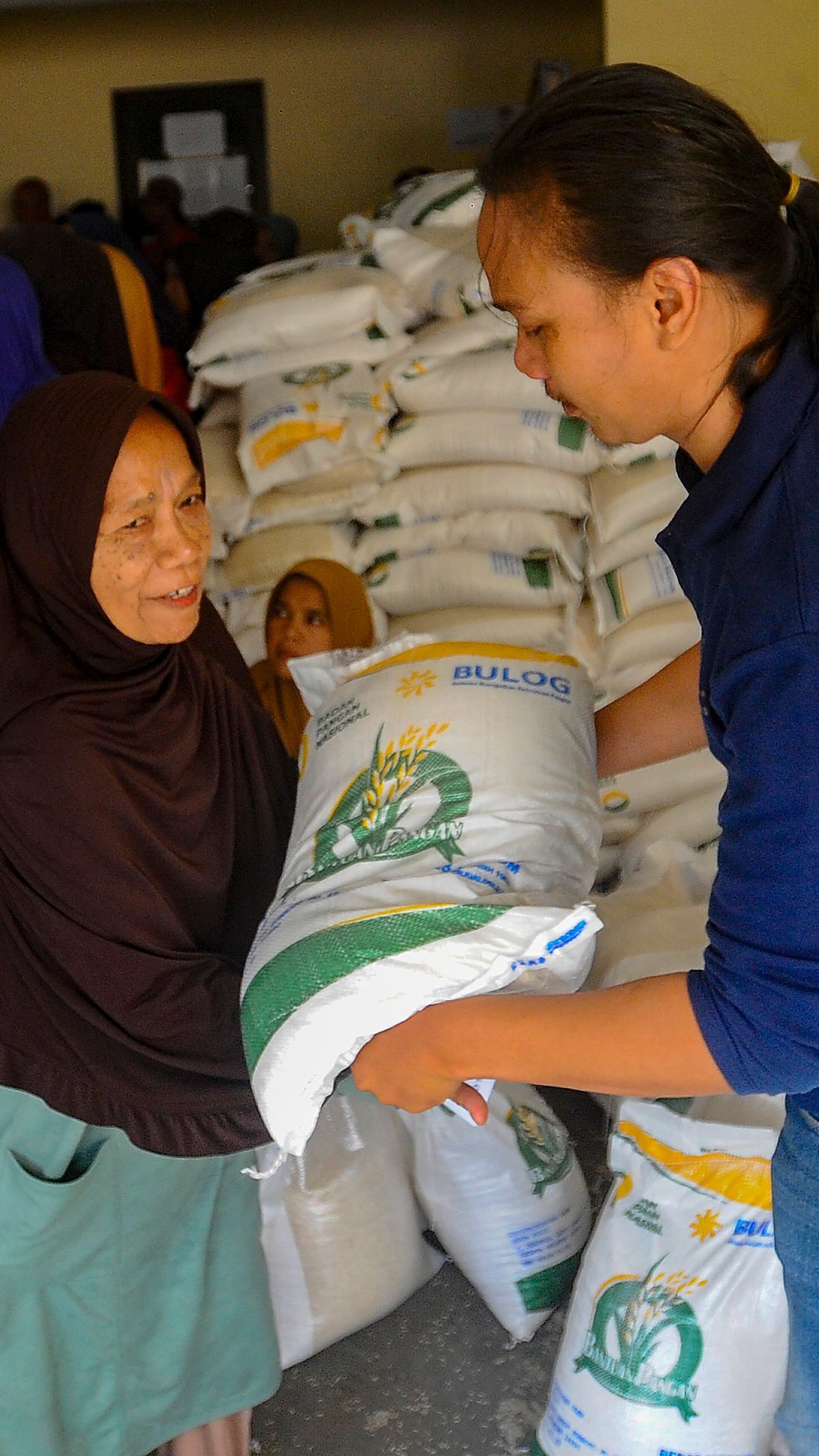 FOTO: Jelang Pemilu, Warga Depok Ramai-Ramai Terima Bansos 10 Kg Beras