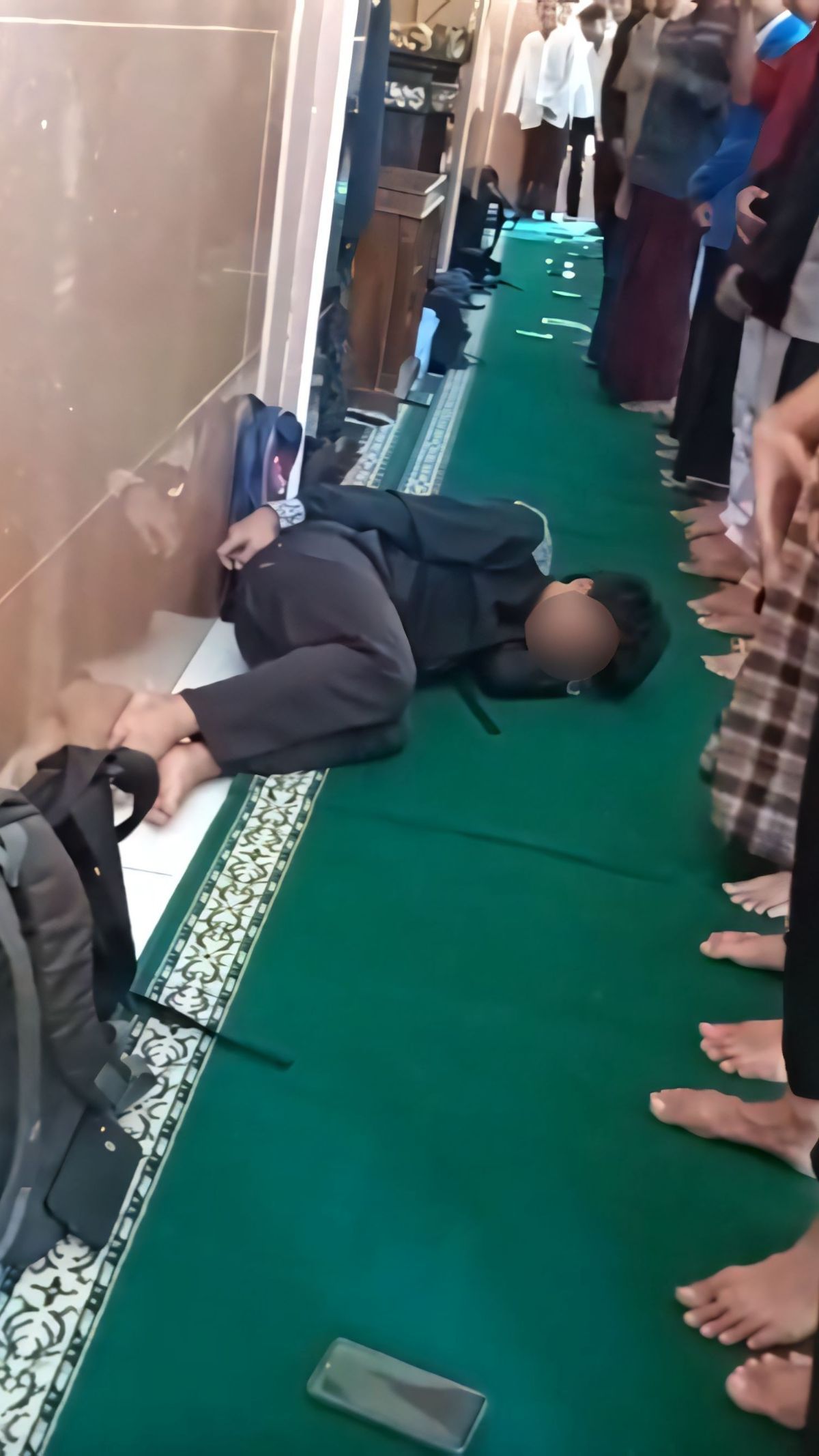 Pria berpeci bersembunyi di balik kain sholat