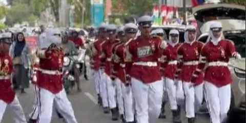 Setelah melanggar barisan pasukan Gerak Jalan, seorang pemotor menjadi viral karena terjebak di tengah mereka.