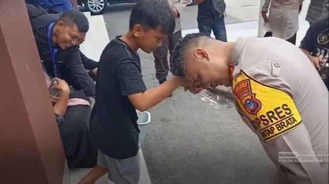 Bocah Penjual Kue Kaget Tangannya Dicium Perwira Polisi 'Eh Terbalik'