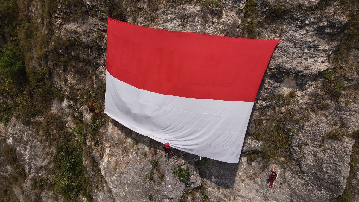 FOTO: Penampakan Gagahnya Merah Putih Raksasa Terbentang di Tebing Gua Lalay Bogor