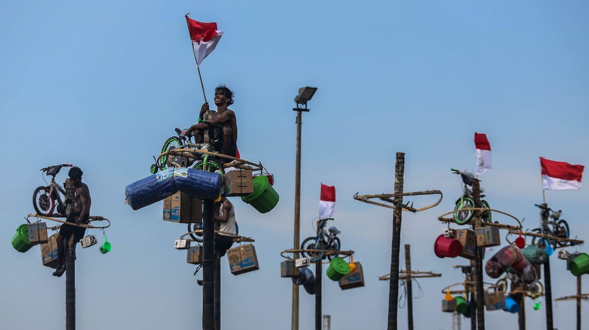 FOTO: Semarakkan HUT RI, Ratusan Orang Ikuti Lomba Panjat Pinang di Ancol Taman Impian