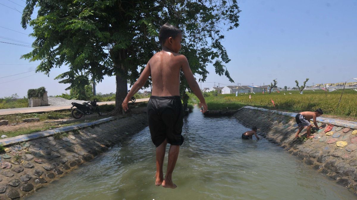 FOTO: Suhu di Bekasi Menyengat, Anak-Anak Asyik Main Air di Saluran Irigasi