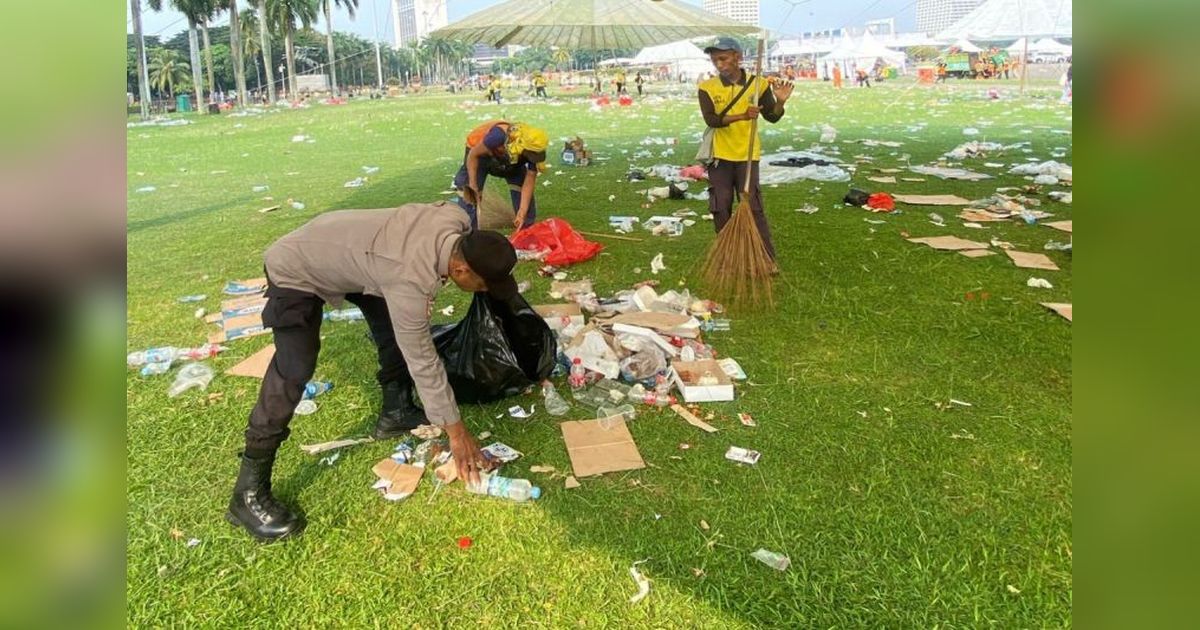 Polisi Bantu Bersihkan Sampah Usai May Day 2025 di Monas, Tunjukkan Sisi Humanis