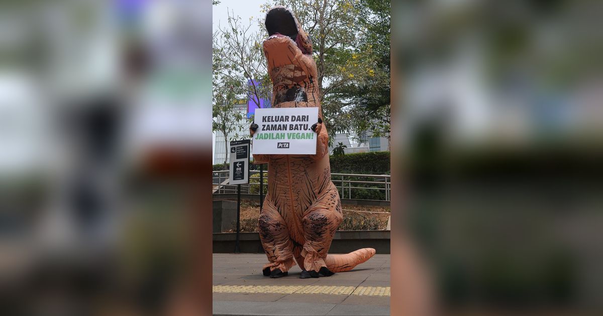 FOTO: Berkostum Dinosaurus, Aktivis PETA Ajak Masyarakat Hidup Vegan Tanpa Eksploitasi Hewan