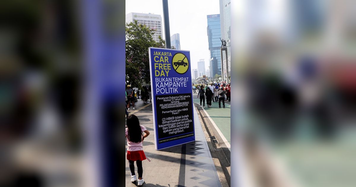FOTO: Banner Larangan Kampanye Politik Mencuri Perhatian Saat Car Free Day di Kawasan Thamrin