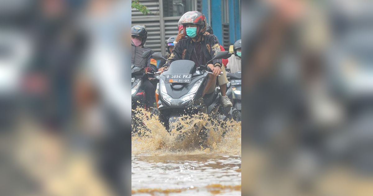 FOTO: Luapan Air Kali Baru di Depan Pasar Induk Kramat Jati Banjiri Jalan Raya Bogor, Lalu Lintas Macet Parah
