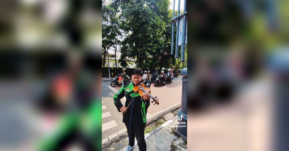 Aksi Pria Berjaket Ojol Main Biola di Lampu Merah Ini Viral, Keren Banget