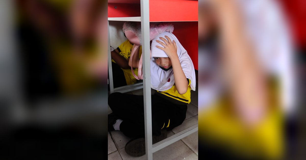 FOTO: Ekspresi Siswa SD di Depok Ikuti Simulasi Gempa, Panik dan Berlindung di Kolong Meja