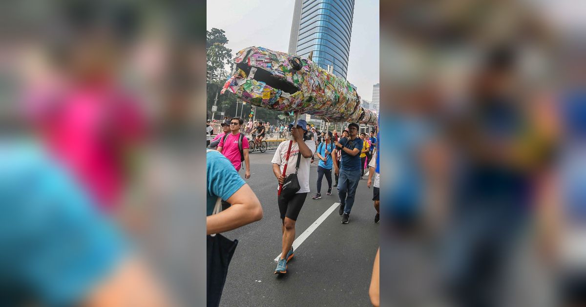 FOTO: Pegiat Lingkungan Pawai Bawa 'Ular Sampah Saset Raksasa' Tuntut Bebas Plastik di Kawasan Bundaran HI