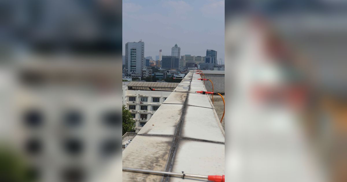 FOTO: Menyemprot Air dari Atap Gedung Jadi Solusi Kurangi Polusi Udara di Jakarta