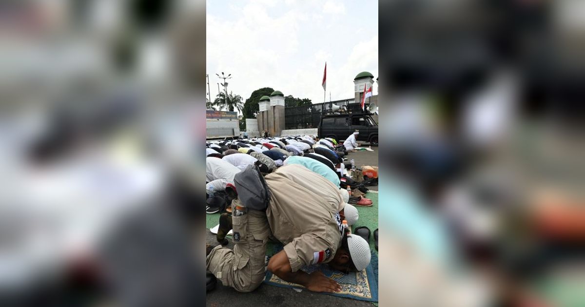 FOTO: Momen Pengunjuk Rasa Tuntut Hak Angket Gelar Jumatan di Depan Gedung DPR